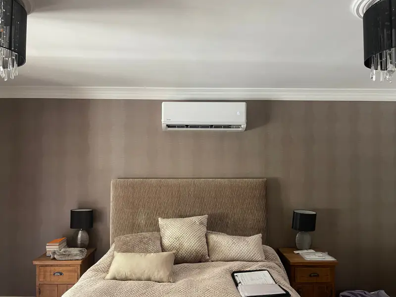 Bedroom air conditioning in York Wall-mounted air conditioning unit above an upholstered headboard in a York bedroom