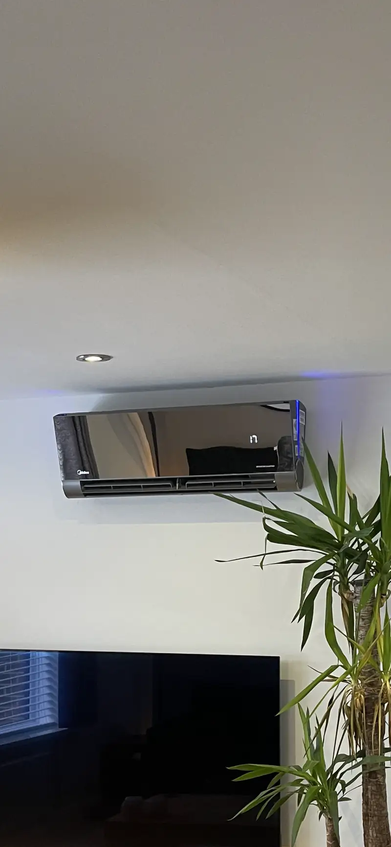 Mirror-finish wall-mounted air conditioner Mirror-finish wall-mounted air conditioner above a television in a modern York living room